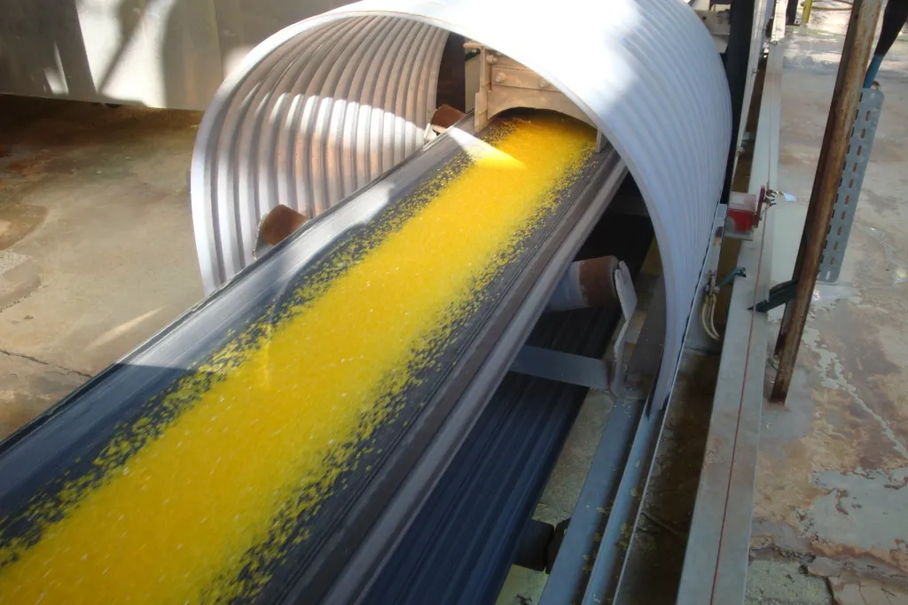 Yellow granular product on a covered belt conveyor