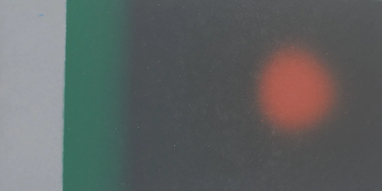 Dunkel beschichtete Fläche mit einem hellen rot-orangen Fleck, wo die Umschlagtemperatur überschritten wurde
